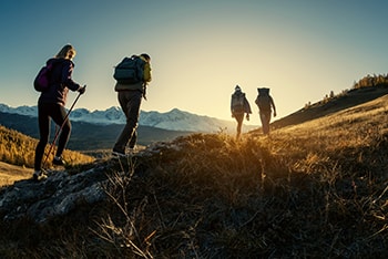 Group of people hiking into sunset